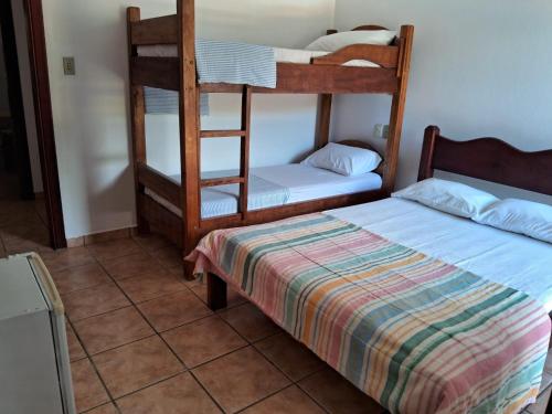 um quarto com 2 beliches e uma cama em Pousada Sol da Lagoinha em Ubatuba