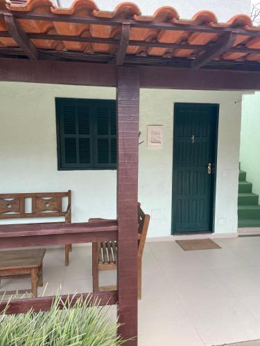 a patio with a green door and benches at Pousada El Camenito Geribá Búzios in Búzios
