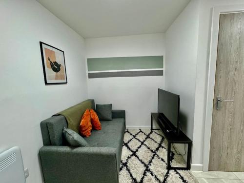 uma sala de estar com um sofá verde e uma televisão em Stylish one bedroom & a sofa bed em Cardiff