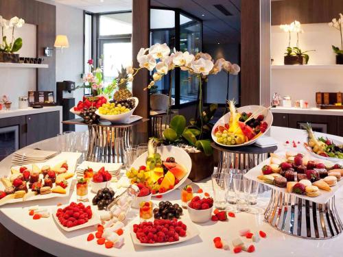 una mesa con muchos platos de comida. en Mercure Paris Porte De Versailles Expo, en París