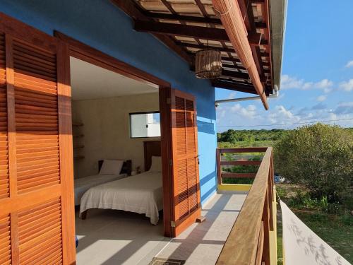 Quintal da Espera - Praia de Itacimirim في كامساري: غرفة نوم مع سرير على شرفة