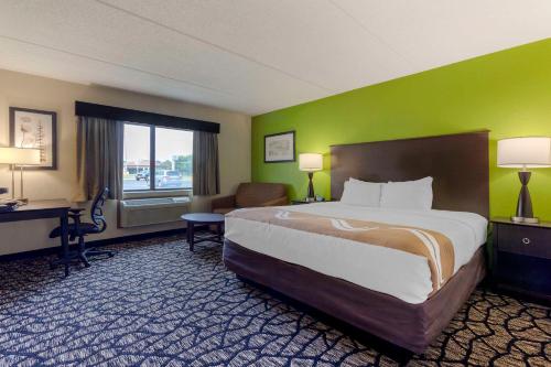 a hotel room with a large bed and a desk at Quality Inn in Oshkosh