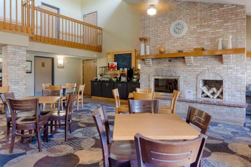 a restaurant with tables and chairs and a fireplace at Quality Inn in Oshkosh