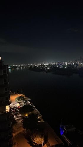 - une vue sur l'eau la nuit avec une ville dans l'établissement شقه فندقيه عائليه اطلاله على النيل بانوراما, au Caire