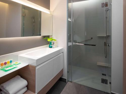 a bathroom with a sink and a shower at Andaman Beach Hotel Phuket - Handwritten Collection in Patong Beach