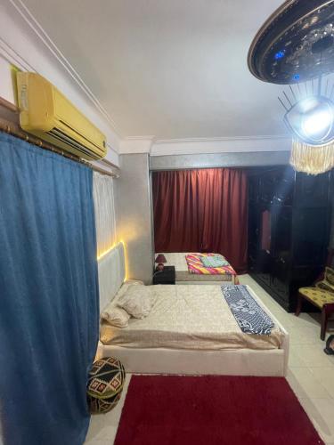 - une chambre avec un lit et un rideau bleu dans l'établissement Studio makram Ebid, au Caire
