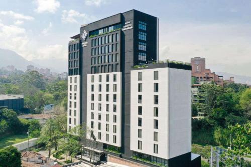 ein hohes weißes Gebäude mit einer Uhr darüber in der Unterkunft Faranda Collection Medellin, a Member of Radisson Individuals in Medellín