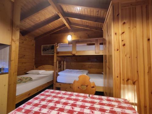 ペーイオにあるCamping Val di Soleのキャビン内の二段ベッド2台が備わる客室です。