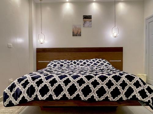 Schlafzimmer mit einem Bett mit einer schwarzen und weißen Bettdecke in der Unterkunft A luxury apartment full furnished ultra modern in Kairo