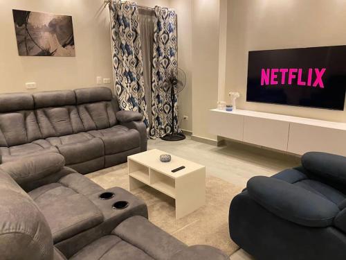 ein Wohnzimmer mit einem Sofa und einem TV in der Unterkunft A luxury apartment full furnished ultra modern in Kairo