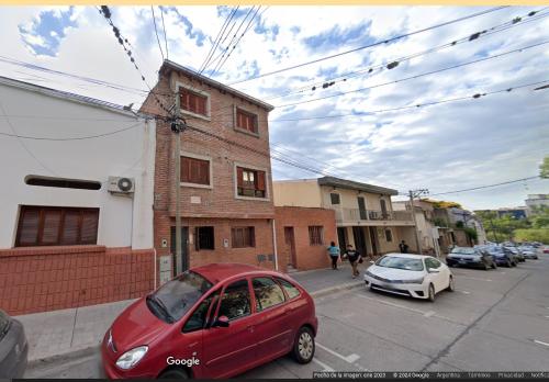 a red car parked on a street next to a building at Hospedaje Familiar Janaq Pacha in San Salvador de Jujuy