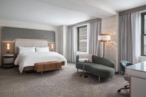 um quarto de hotel com uma cama e uma cadeira em The Westin Book Cadillac Detroit em Detroit