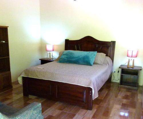 Un dormitorio con una cama con una almohada azul. en Jardines del Golfo en Lepanto