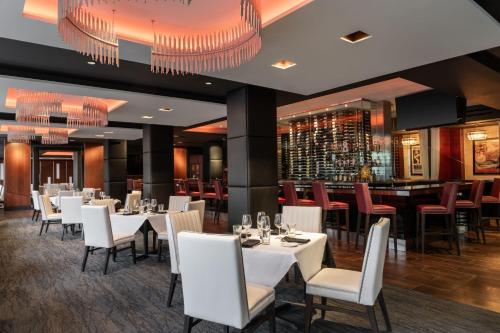 a restaurant with white tables and chairs and a bar at The Westin Book Cadillac Detroit in Detroit