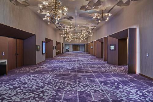 an empty hallway with a tile floor and a chandelier at Walt Disney World Swan Reserve in Orlando