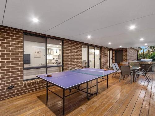 a ping pong table in a room with a brick wall at Yarra Valley on the Warburton Trail in Wandin North
