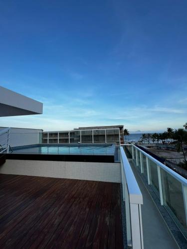 un edificio con piscina in cima a una terrazza di Apartamento aconchegante de 3/4 na beira da praia! a Ilhéus