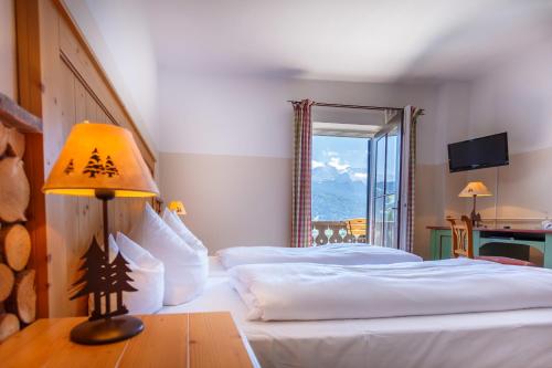 a hotel room with two beds and a table with a lamp at Landkomforthotel Panorama & Restaurant Bella Vista in Garmisch-Partenkirchen