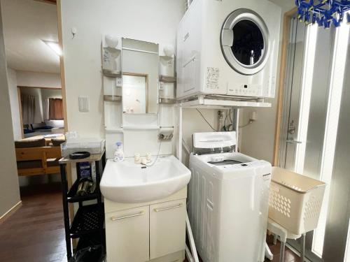 a bathroom with a sink and a washing machine at アイコニー in Miyako Island