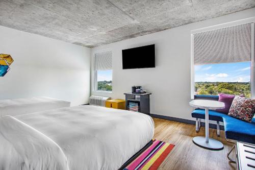 a white bedroom with a bed and a window at Aloft Delray Beach in Delray Beach