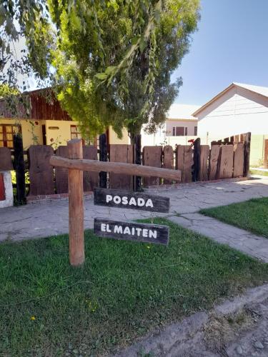 a wooden bench with street signs in the grass at Posada El Maiten in Trevelin