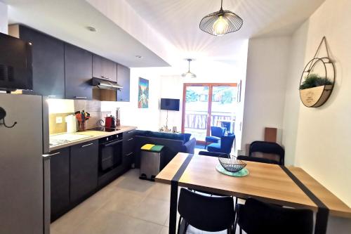 eine Küche und ein Esszimmer mit einem Tisch und einem Kühlschrank in der Unterkunft Superbe appartement au pied des pistes in La Feclaz