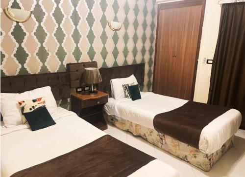 um quarto de hotel com duas camas e um candeeiro em Golden Sun Hotel - Hurghada em Hurghada