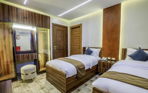 a hotel room with two beds and a mirror at Piccolo Mondo Boutique Hotel in Cairo