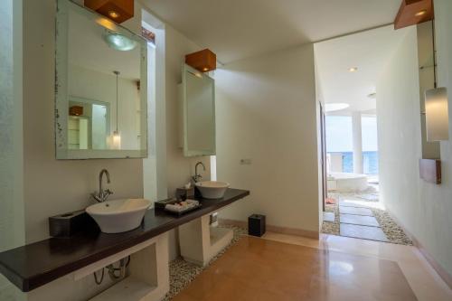 a bathroom with two sinks and a mirror at Lawira Beach Villa Lovina in Lovina