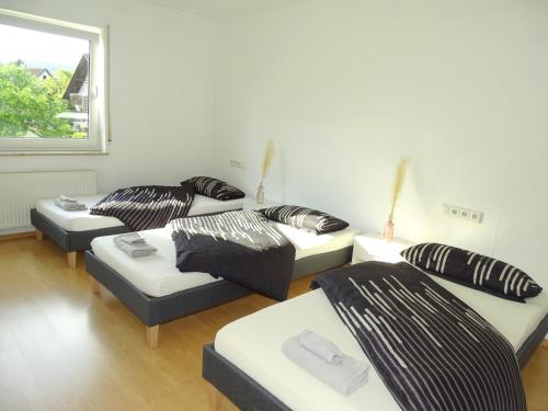 a living room with three couches and a window at Schöne Wohnung bis zu 6 Personen in Herzen von Rudersberg in Rudersberg