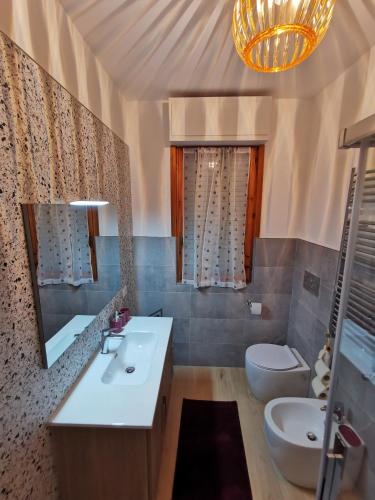 a bathroom with a sink and a toilet and a mirror at Colour House in Rome