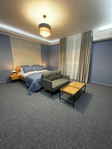 a bedroom with a bed and a couch and a table at Hotel Residenz Luxury - Outletcity - Parken - Klima - 24h Check-In in Metzingen