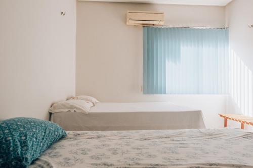 a bedroom with two beds and a window at Casa de Praia com piscina em Luis Correia - Piaui in Luis Correia