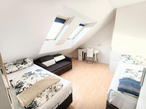 a attic bedroom with two beds and a couch at FMI9Accomation Raunheim in Raunheim