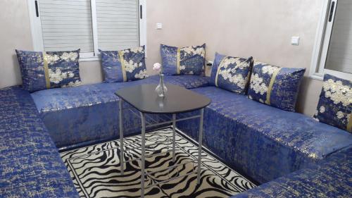 een blauwe bank met een tafel in een kamer bij Manar appart in Marrakesh