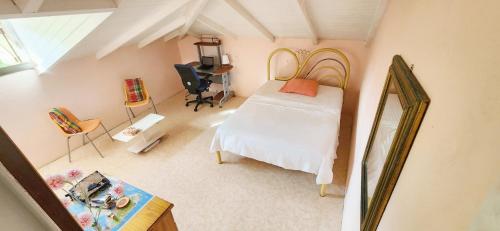 a bedroom with a bed and a desk with a mirror at Chambre Créole in Capesterre-Belle-Eau