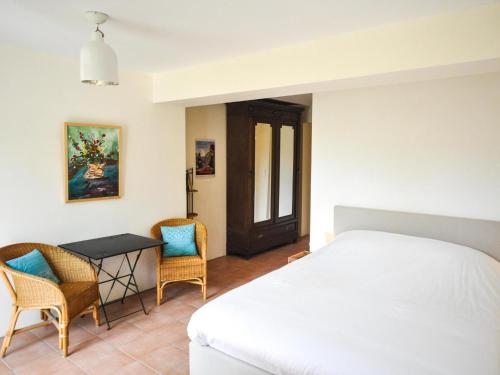 um quarto com uma cama, uma mesa e cadeiras em Villa au calme avec piscine em Cazedarnes