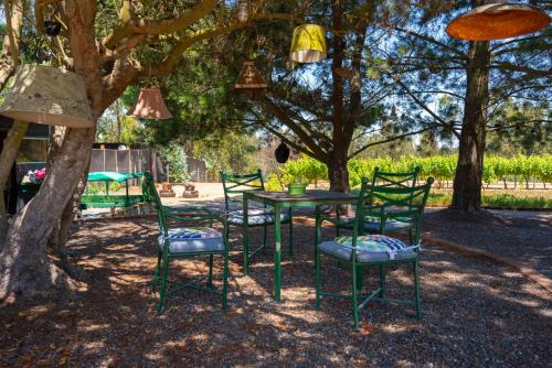a table and chairs sitting under a tree at Preciosa Parcela con puestas de sol, Algarrobo in Algarrobo