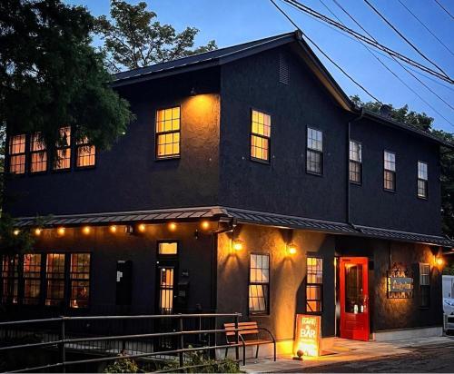 una casa negra con una puerta roja en una calle en Shinkyo Inn, en Nikko