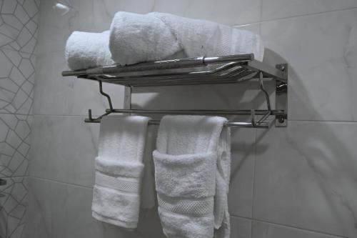 un baño con toallas blancas en un toallero. en Motel Abdelhamid, en Ouled Moussa