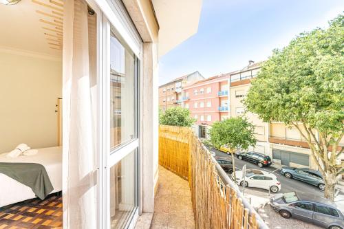 een balkon met een bed en uitzicht op een straat bij Goa Square by Lisbon with Sintra in Amadora