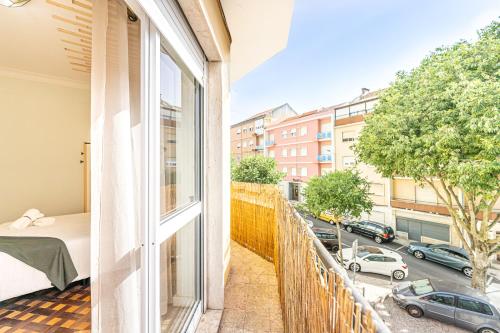 a balcony with a bed and a view of a street at Goa Square by Lisbon with Sintra in Amadora