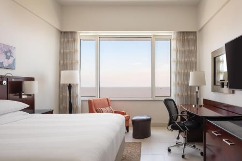 a hotel room with a bed and a desk and a window at Guyana Marriott Hotel Georgetown in Georgetown