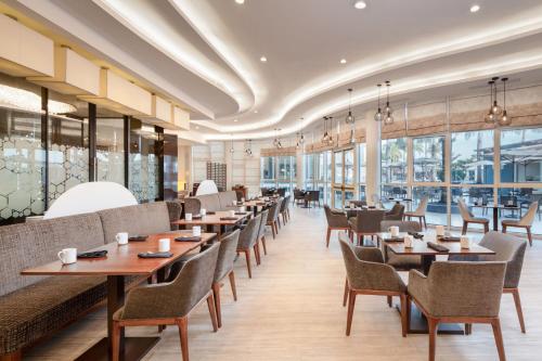 a restaurant with tables and chairs and windows at Guyana Marriott Hotel Georgetown in Georgetown
