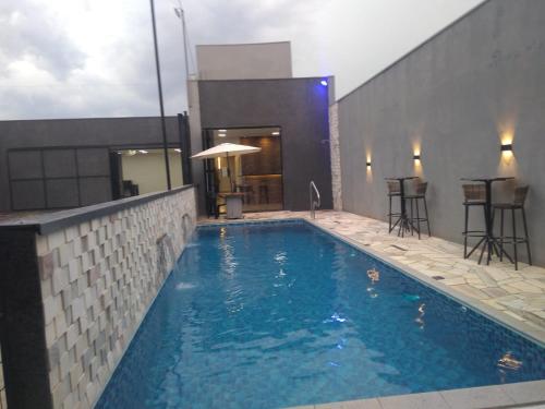 ein Pool mit blauem Wasser in einem Gebäude in der Unterkunft Área de Lazer e Hospedagem completa in Ribeirão Preto
