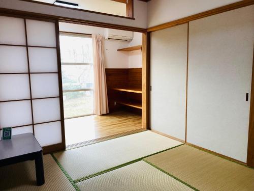 an empty room with a door and a window at 山茶小屋 
