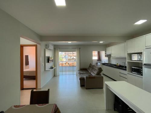 a large living room with a couch and a kitchen at Residencial Helena in Porto Belo