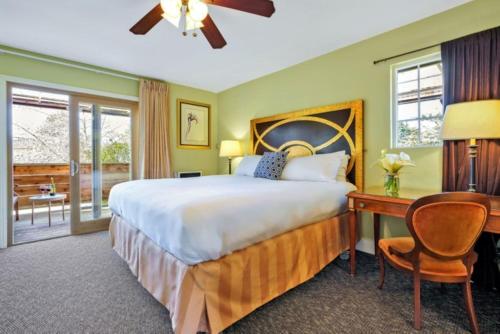 a bedroom with a large bed and a desk and a table at Bodega Bay Inn in Bodega Bay