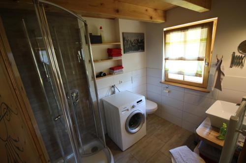 a bathroom with a shower and a washing machine at Kasimir Hof in Seebach