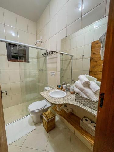 a bathroom with a sink and a toilet and a shower at Camacica pousada in Miracatu